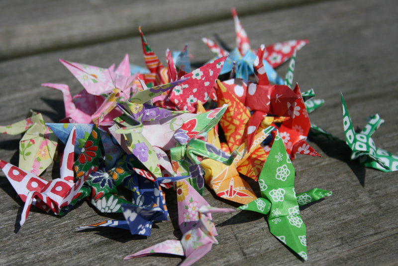 Origami Kraniche bunt auf Holztisch